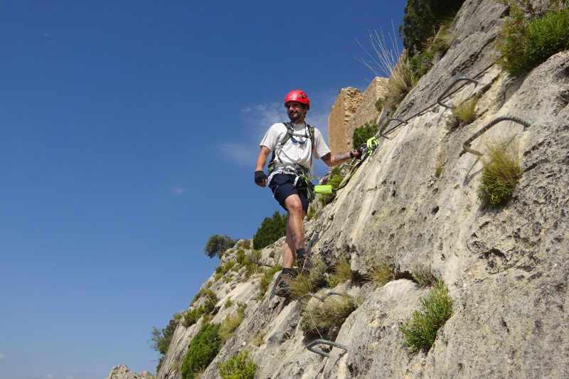 subiendo la vía ferrata de castellote con el castillo detrás